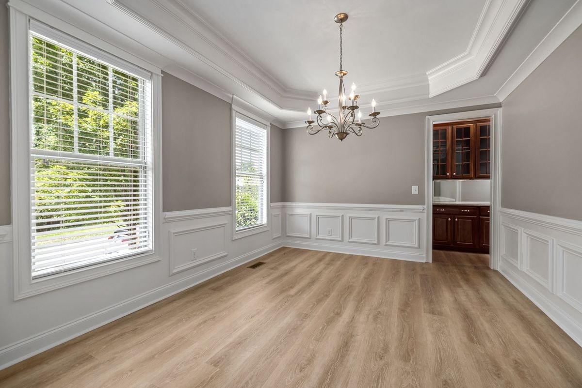 Before: empty dining room with chandelier, wainscoting and light wood-look floor (free-license demo photo), original
